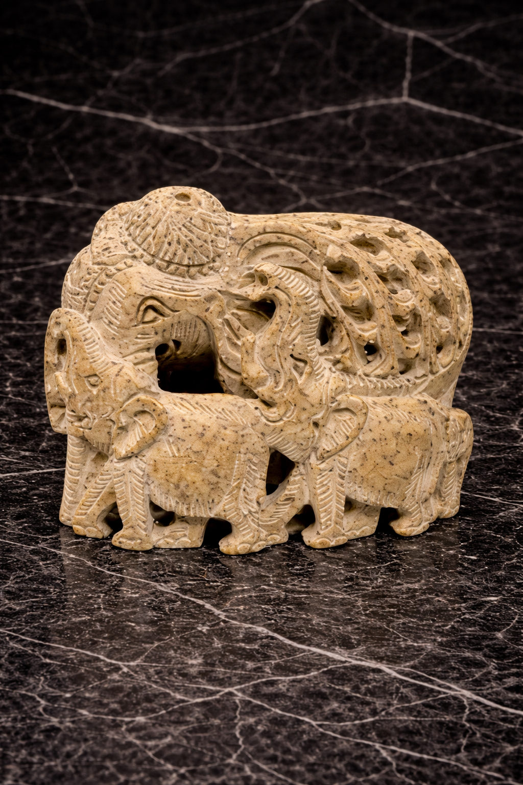 Hand carved soapstone curved elephant family sculpture with intricate detailing on black marble background NZ