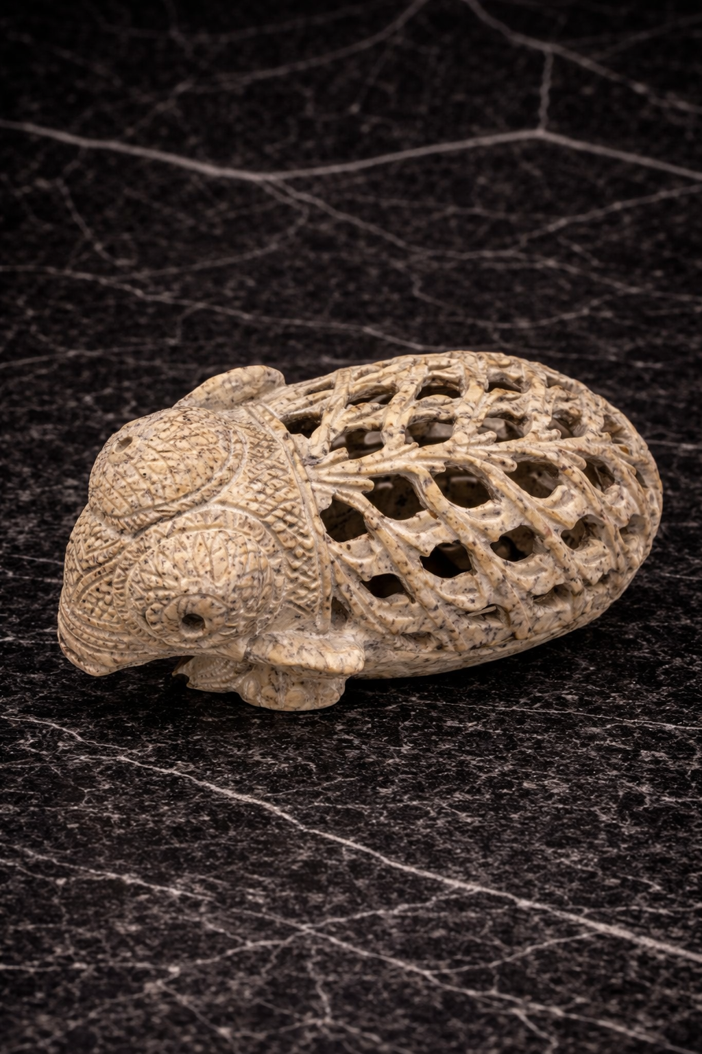 Hand carved soapstone elephant sculpture with lattice shell detailing on black marble background NZ