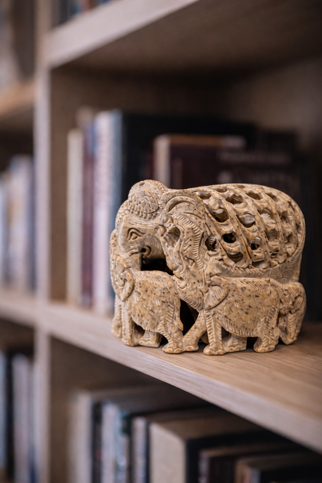 Soapstone elephant family statue displayed on book self