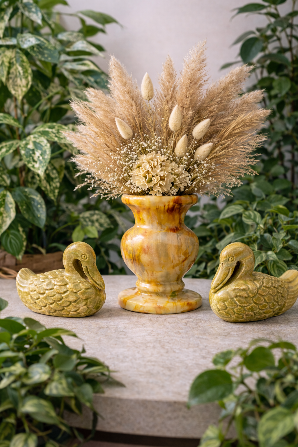 Pair of hand-carved soapstone duck figurines styled with flower vase in modern neutral home