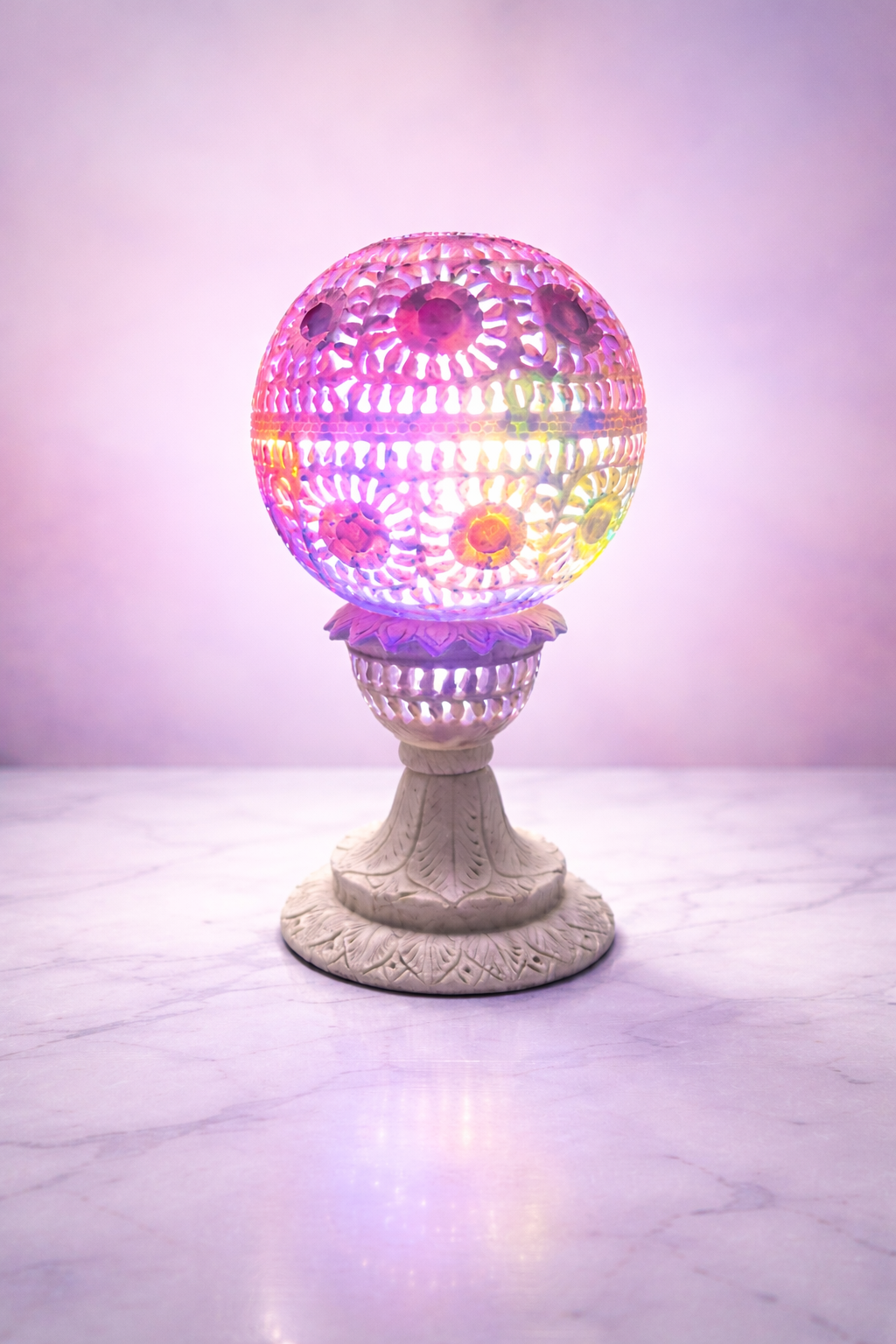 Decorative soapstone tealight holder illuminating console table with colourful glow