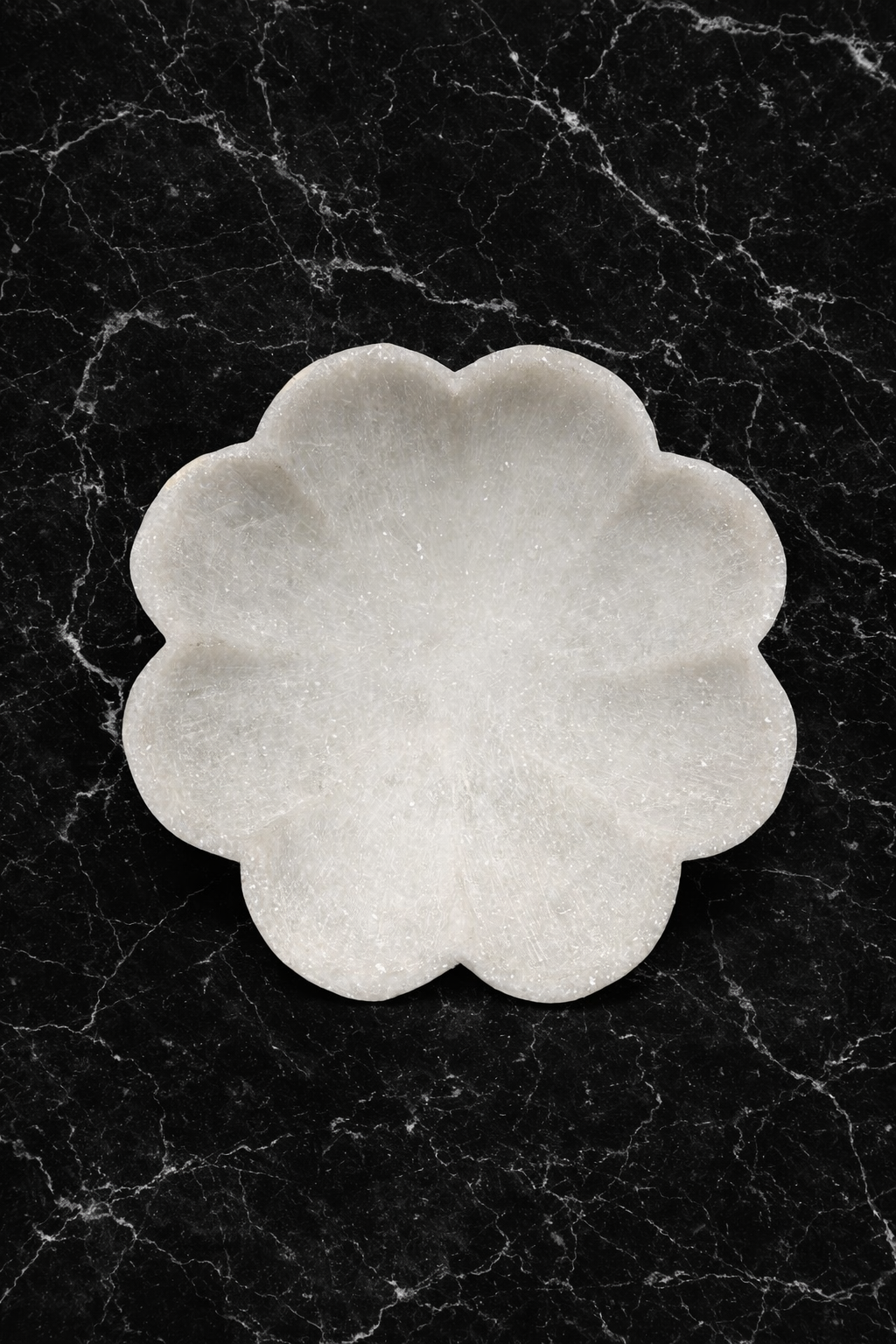 top view of Luxury white marble lotus bowl on black marble surface