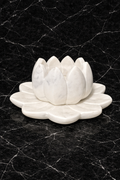 Hand-carved white marble lotus tealight holder on black marble surface, luxury stone candle décor NZ