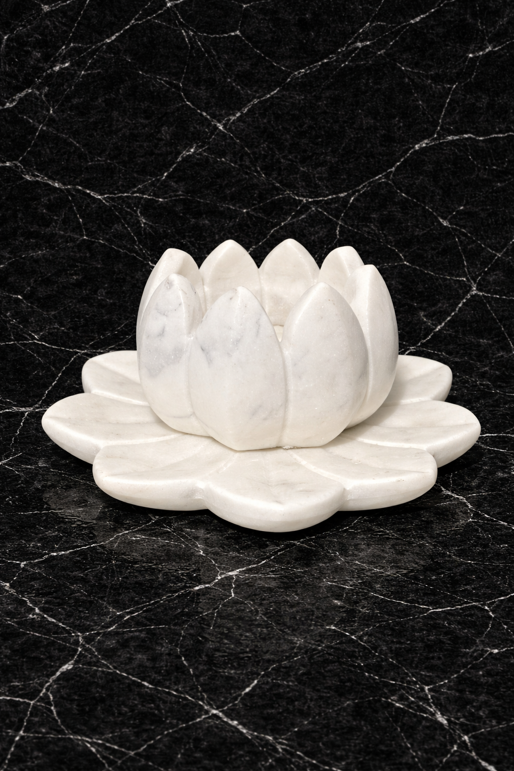 Hand-carved white marble lotus tealight holder on black marble surface, luxury stone candle décor NZ