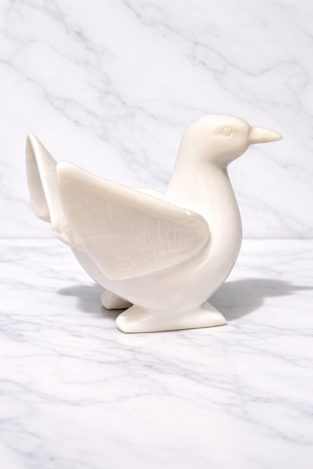 White marble dove sculpture on white marble background