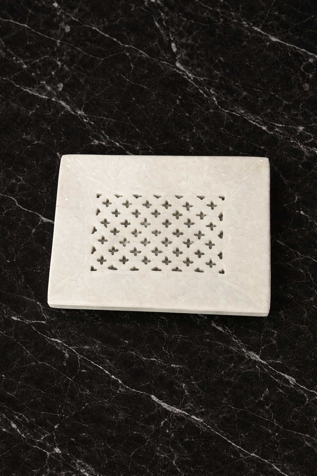Perforated white marble soap tray on dark marble luxury bathroom decor NZ.
