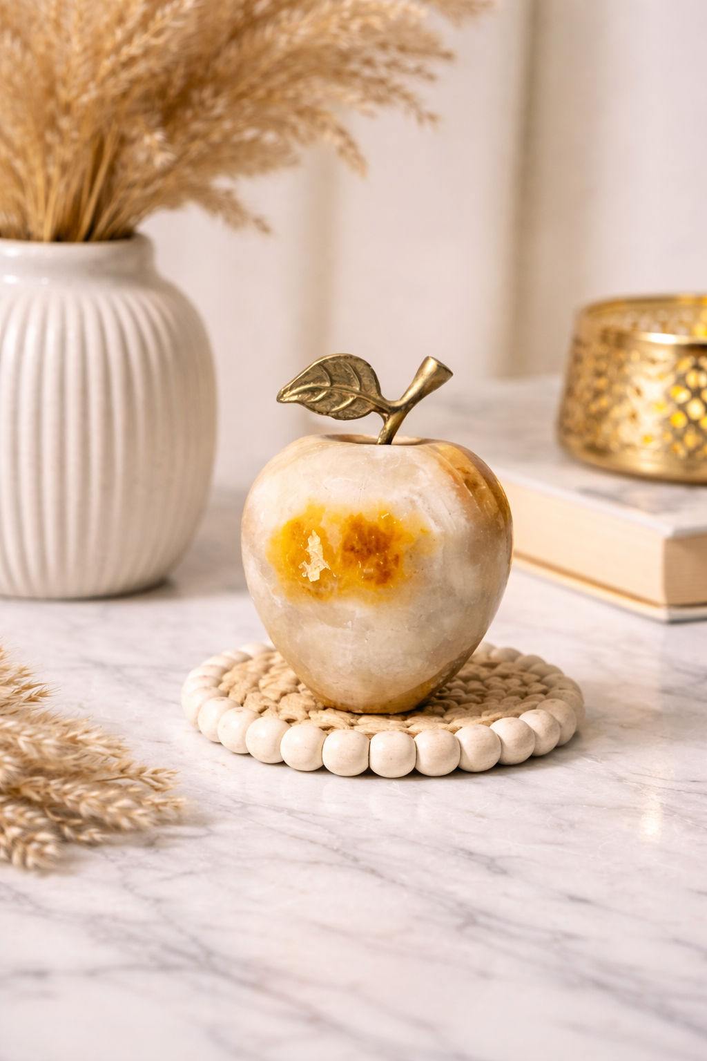 Onyx apple decor with metal leaf stem on a marble surface