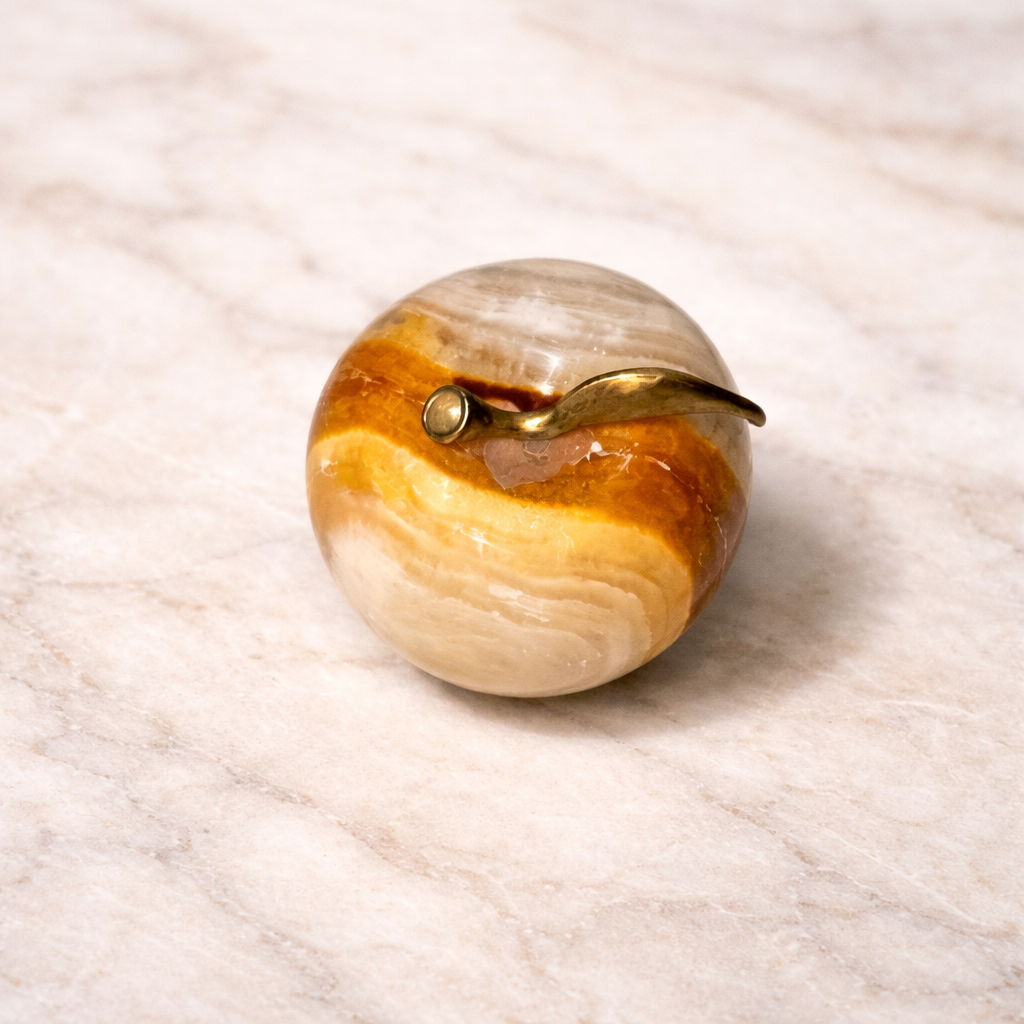 Top view for Onyx apple decor with metal leaf stem on a white marble surface