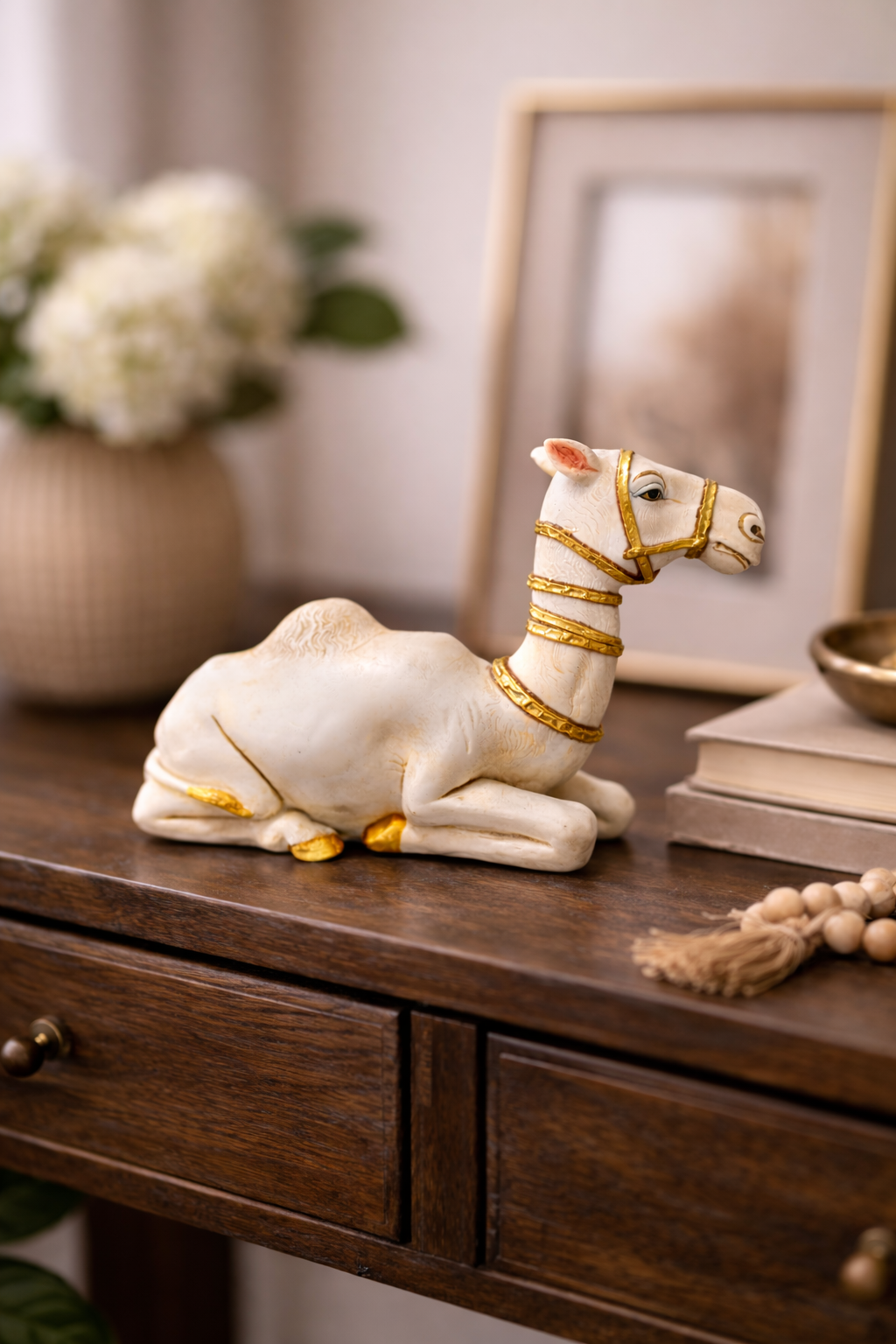 White camel figurine with gold accents on a wooden table