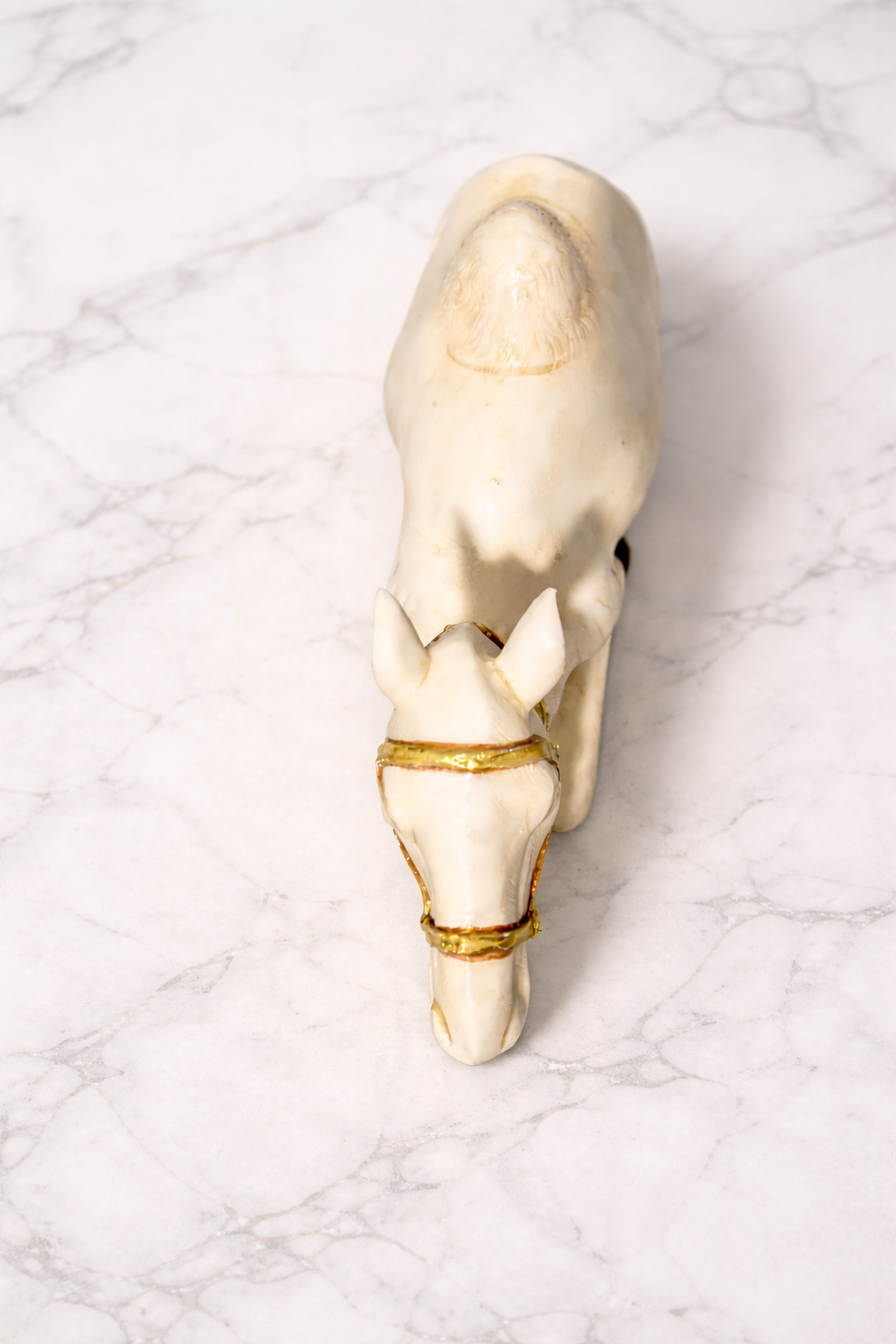 Top view of a camel figurine on white marble