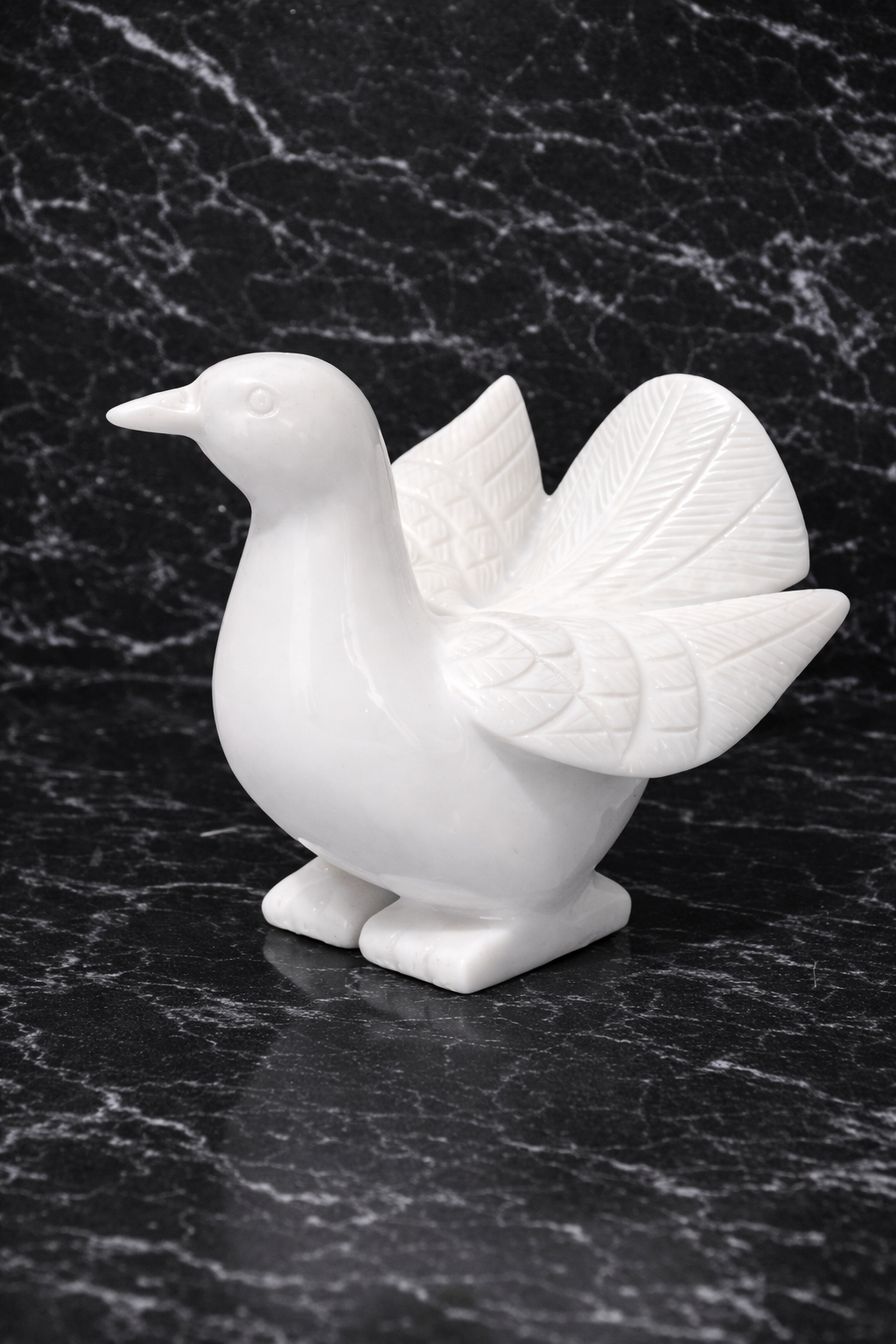 White marble dove statue styled on dark marble