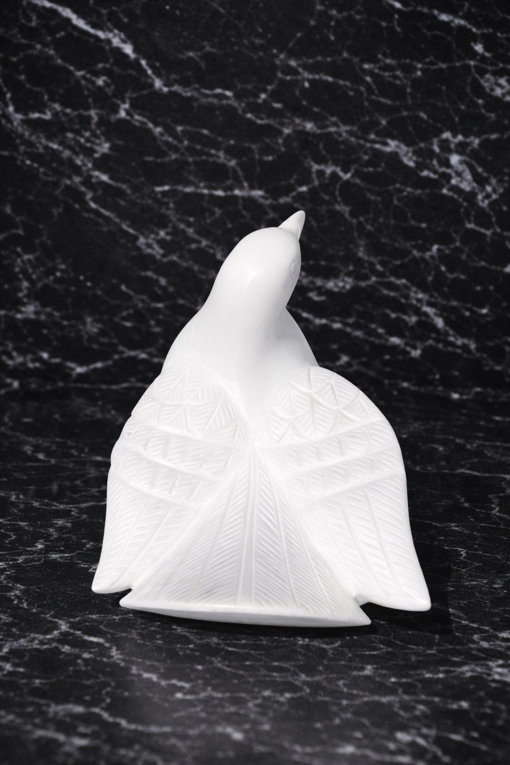 Solid white marble bird statue with detailed carved wings