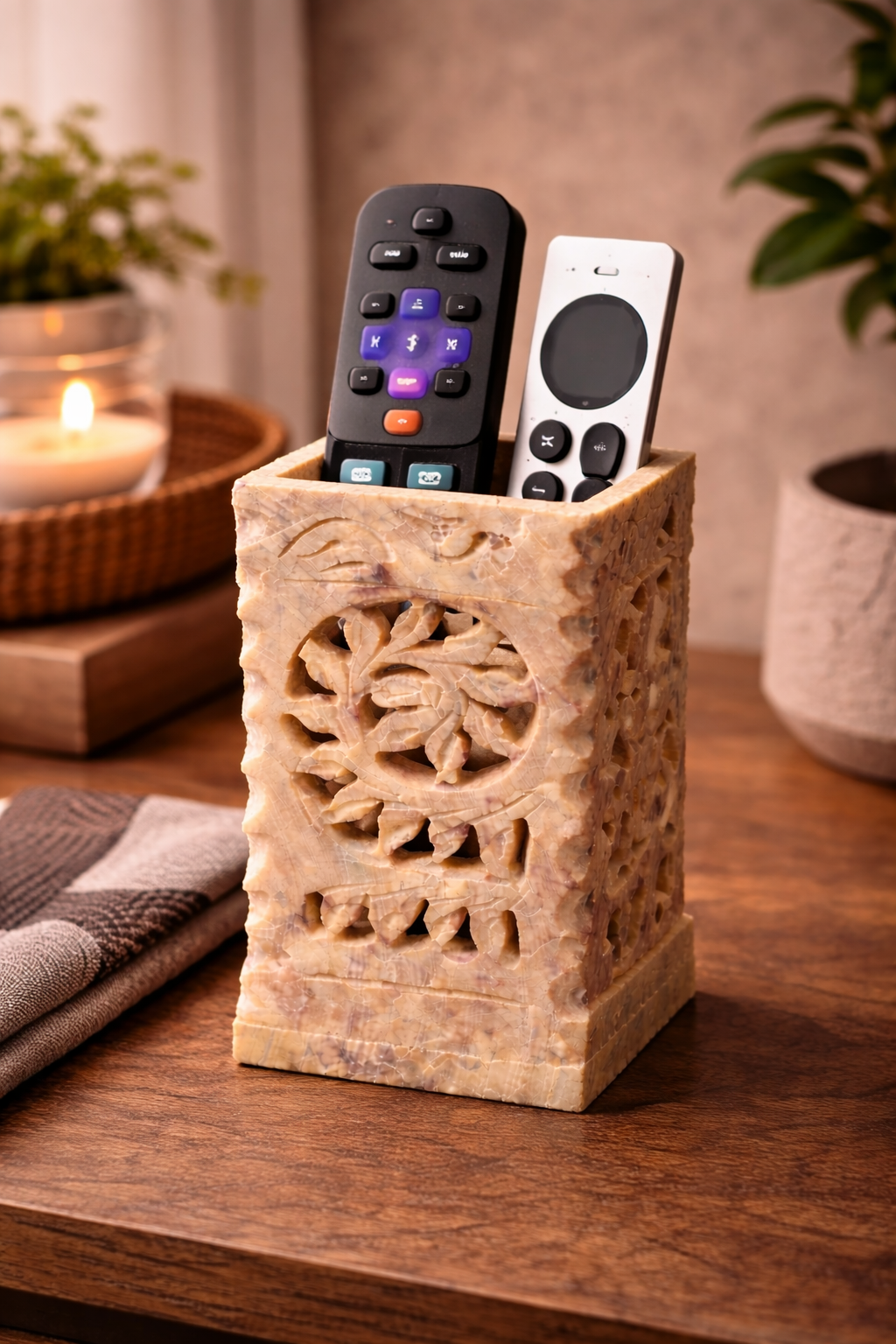 Floral carved soapstone stand used to store everyday household items on a shelf.