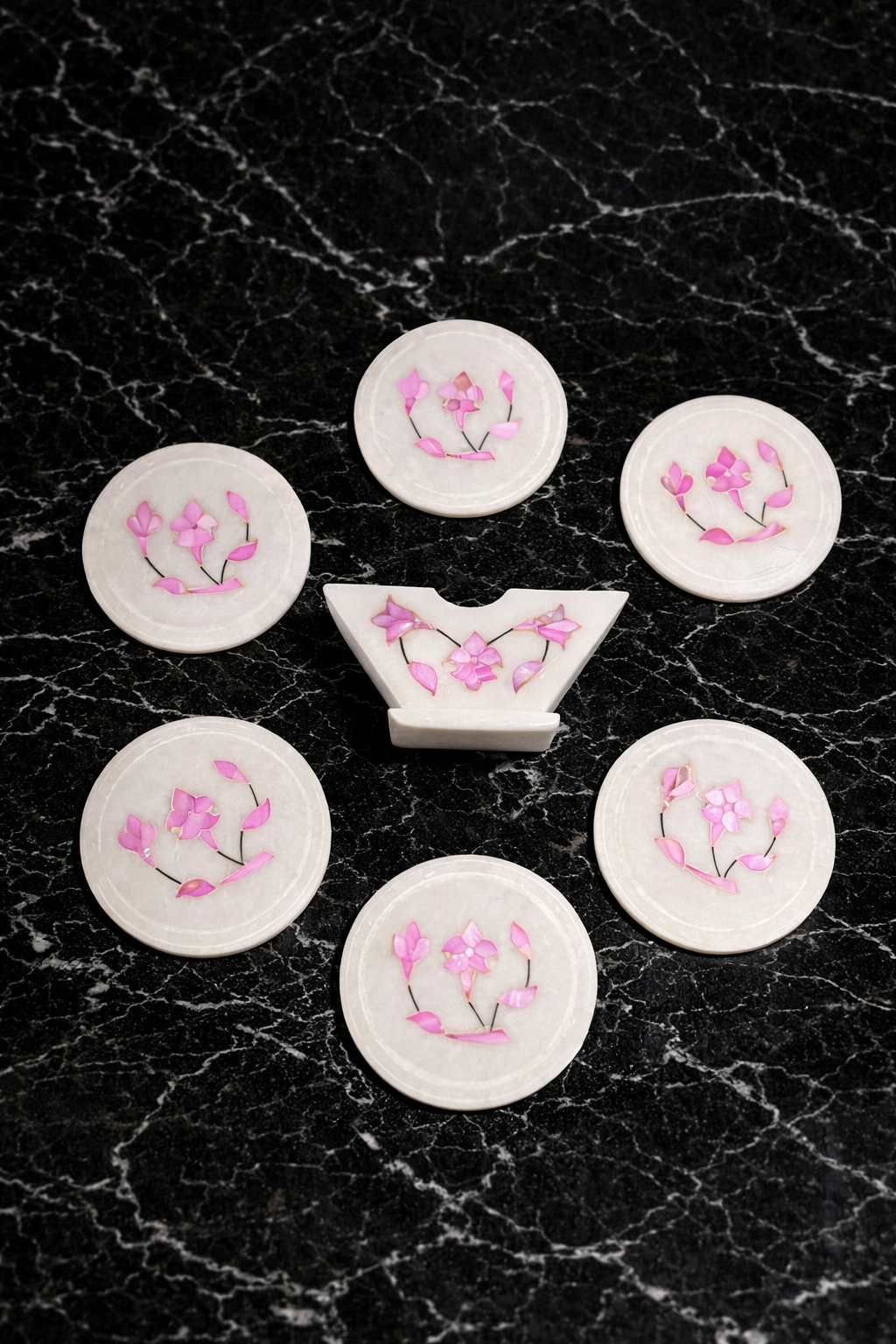 Handcrafted marble coaster set with multicolour floral inlay and holder on black marble surface – luxury drink coasters NZ