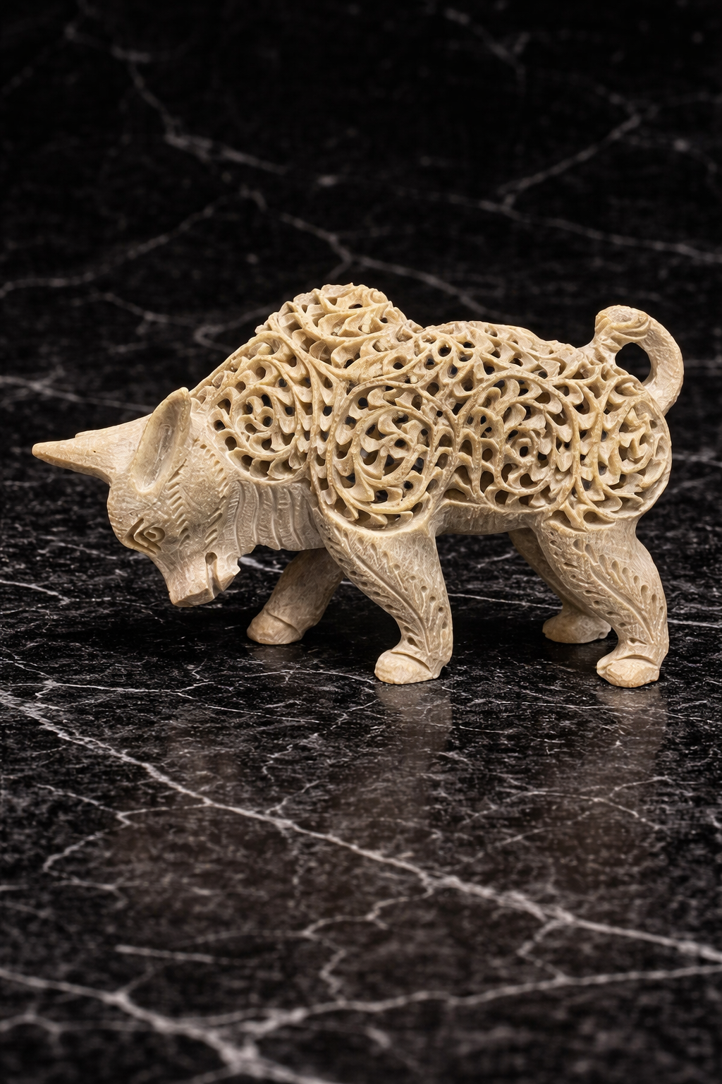 Hand carved soapstone bull sculpture with hidden baby bull inside on black marble background – decorative stone bull statue NZ