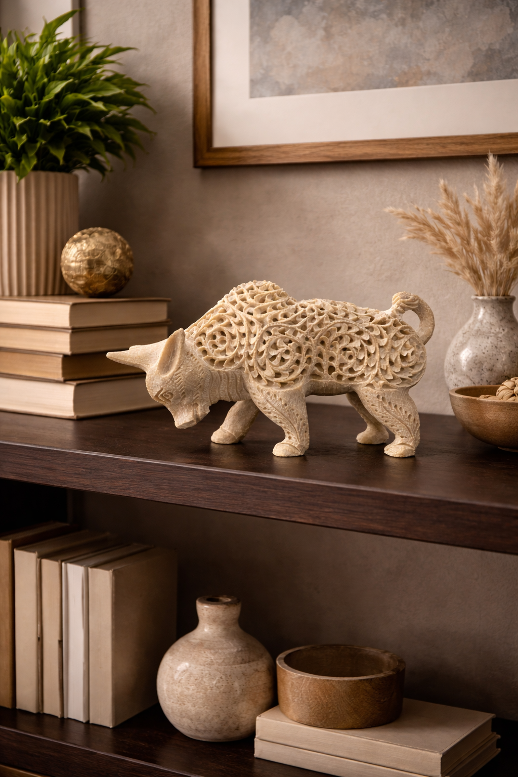 Decorative soapstone bull statue placed on modern living room shelf with books and vases