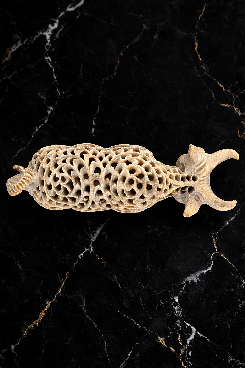 Top view of handcrafted soapstone bull sculpture with intricate openwork stone carving pattern