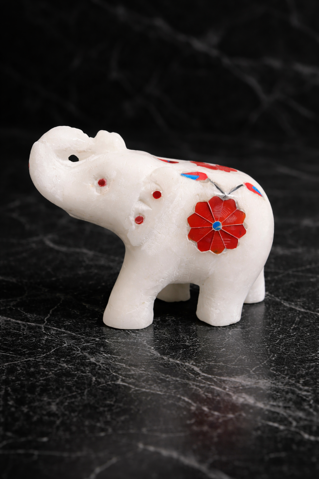 white marble elephant decor with red inlay on black marble background NZ