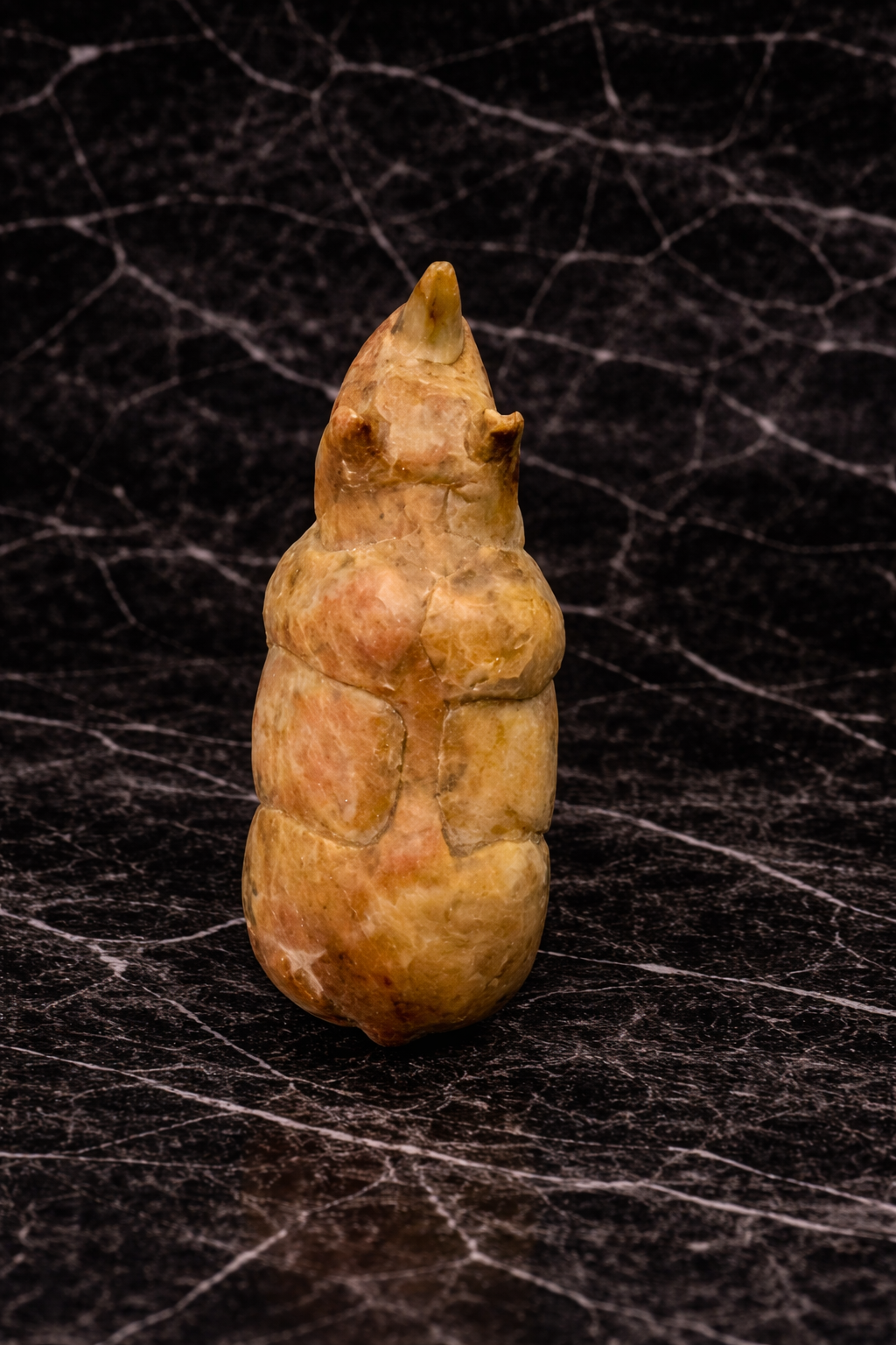 Top view of handmade soapstone rhino animal figurine on black marble background
