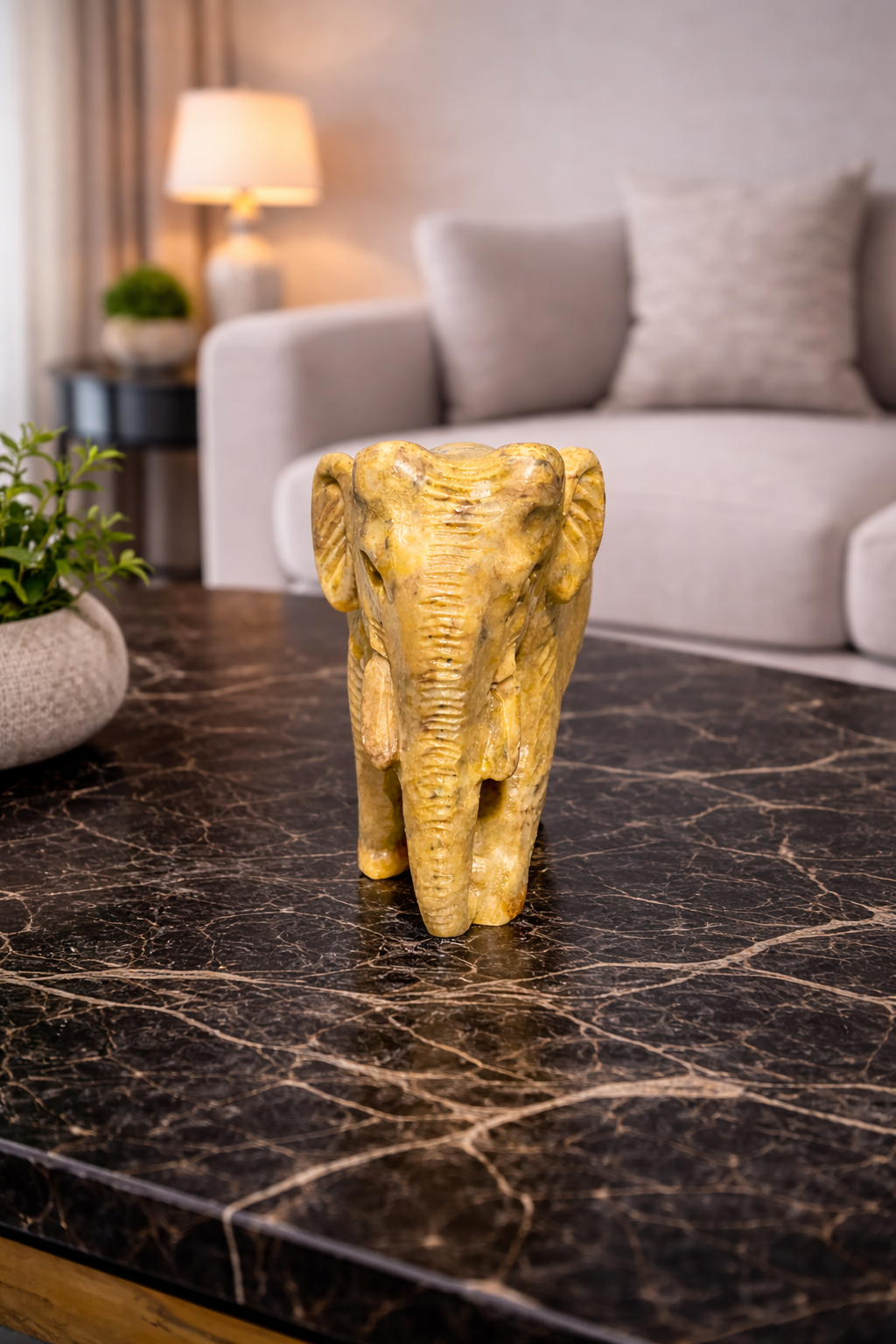 Decorative polished stone elephant sculpture for coffee table or shelf decor in living room.