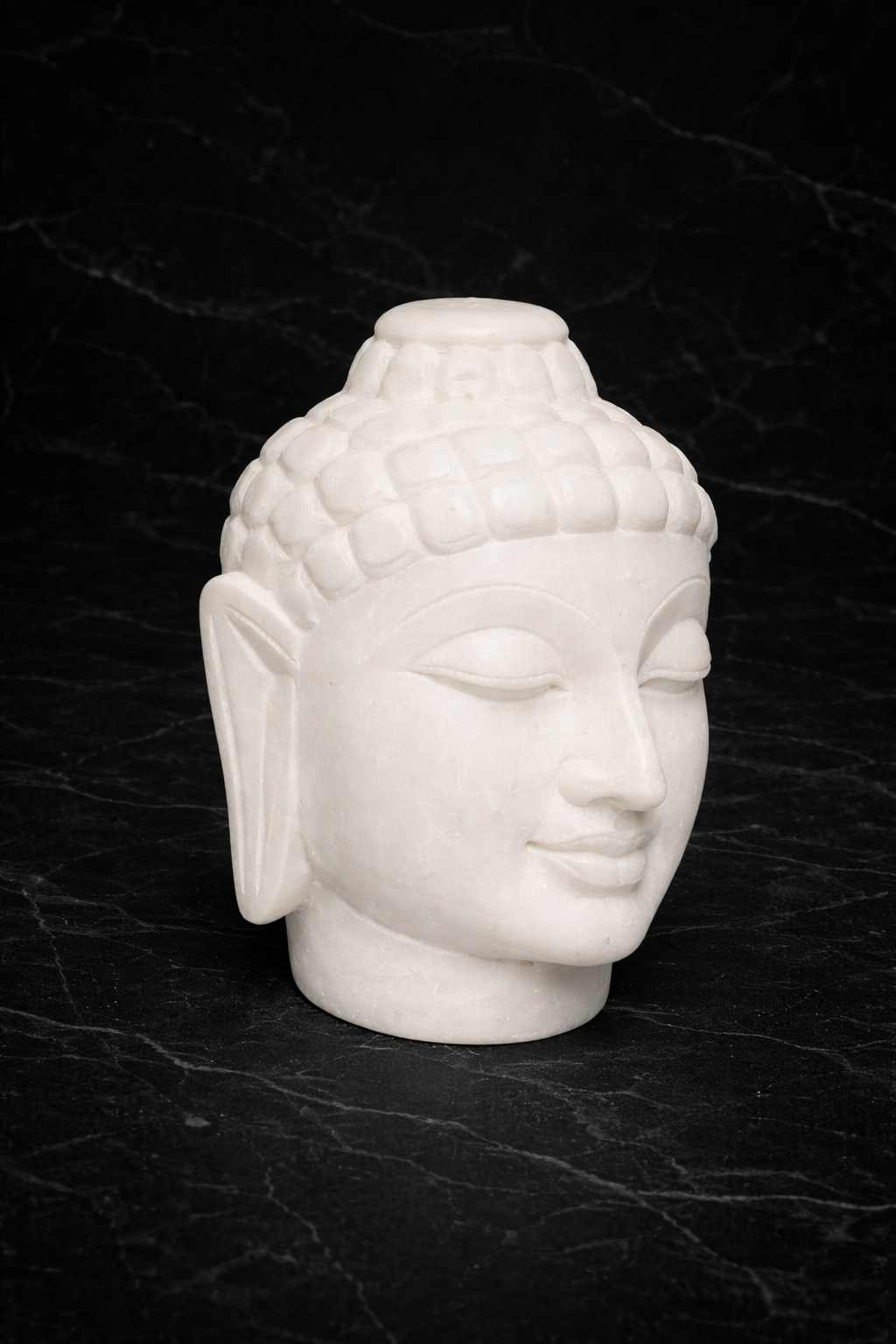 Decorative white marble Buddha head sculpture with dark marble background