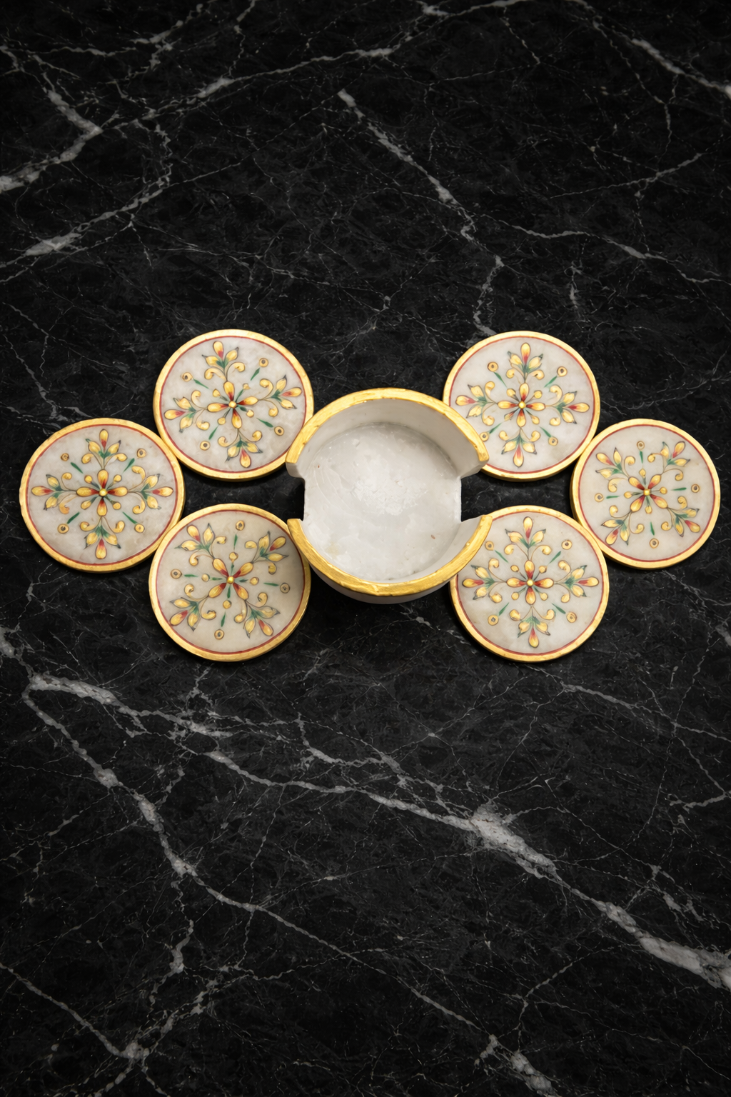 Hand-painted white marble coaster set with floral design and central holder displayed on black marble background, luxury handcrafted marble table décor.