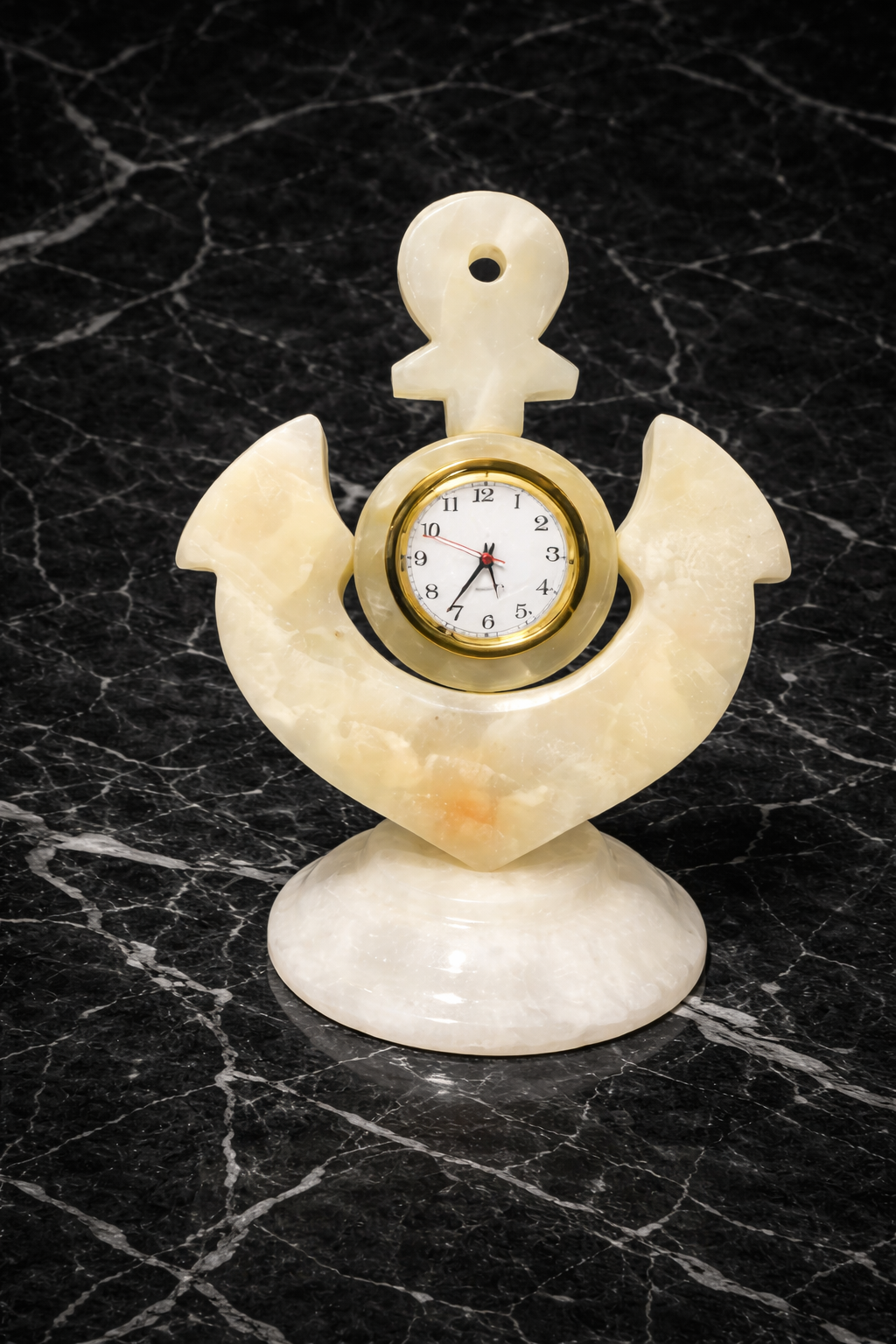 Handcrafted white marble anchor desk clock with gold dial displayed on black marble background, luxury nautical marble décor