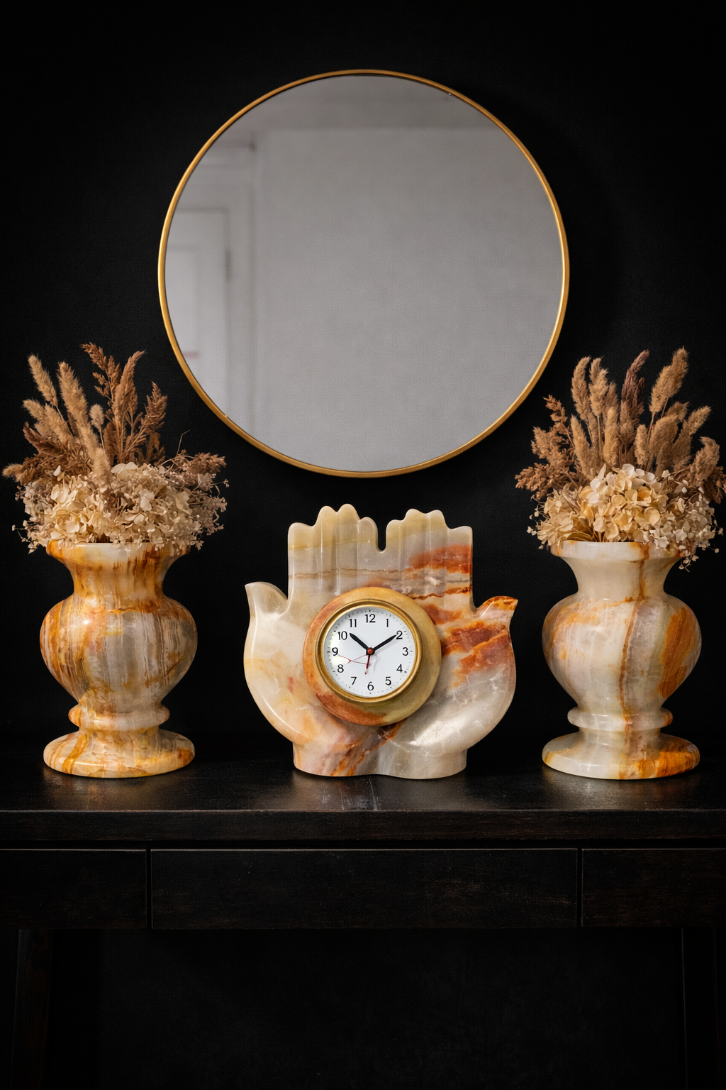 Hand carved natural onyx hand clock displayed on console table with decorative stone vases and round mirror luxury home décor