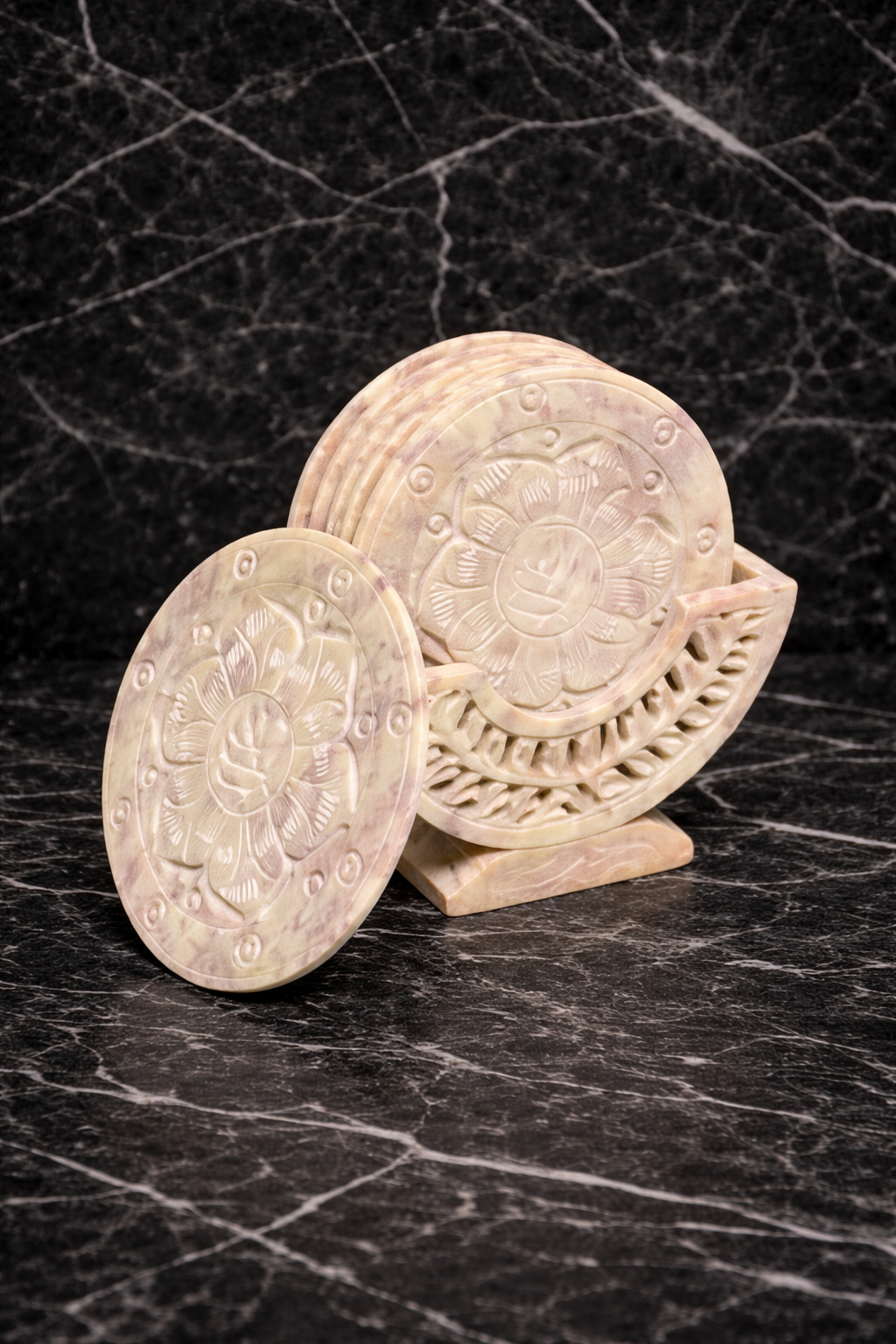 Hand-carved soapstone lotus coaster set with holder on black marble table
