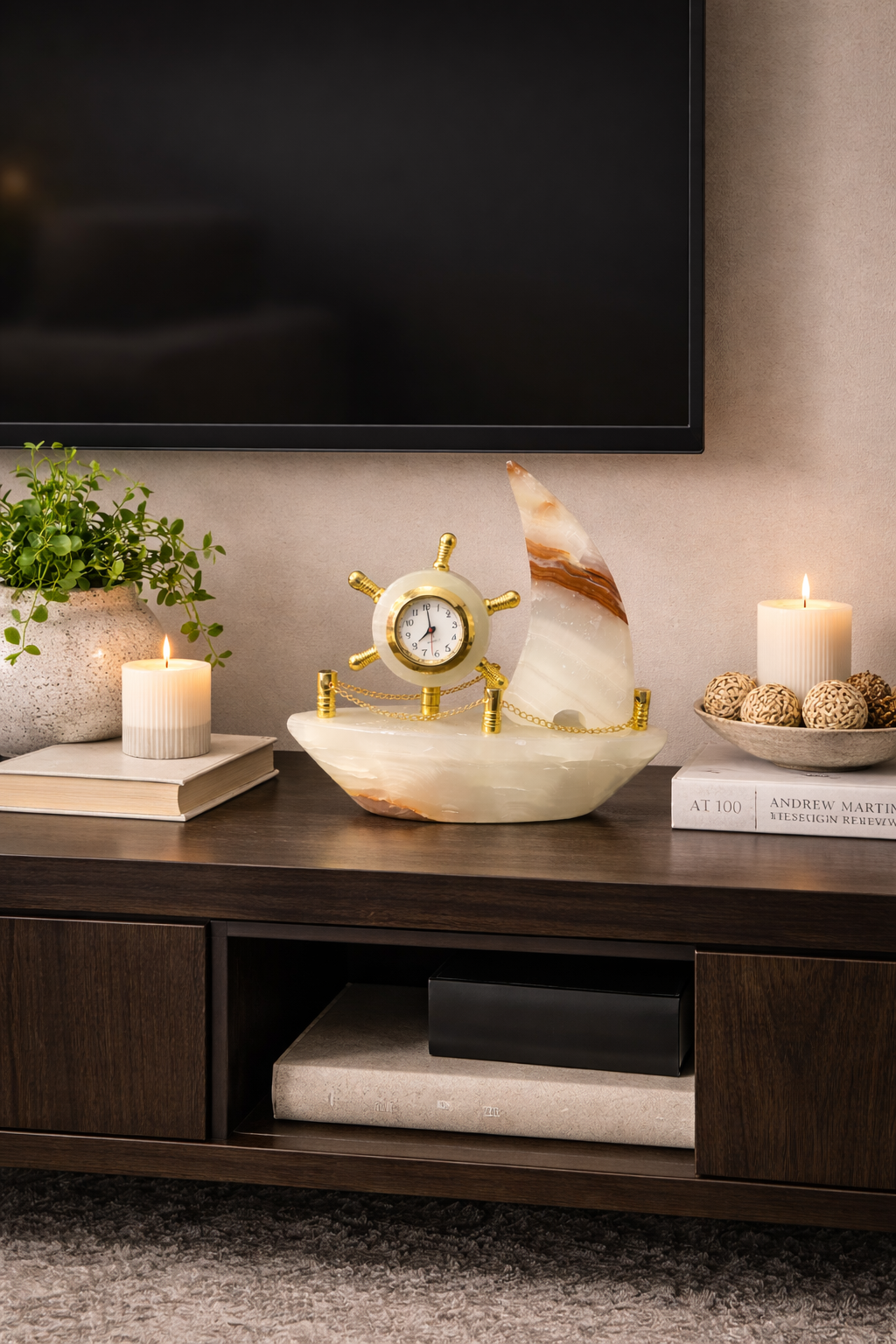 Onyx ship clock decorative sculpture on TV console table with candles and plants, nautical living room decor