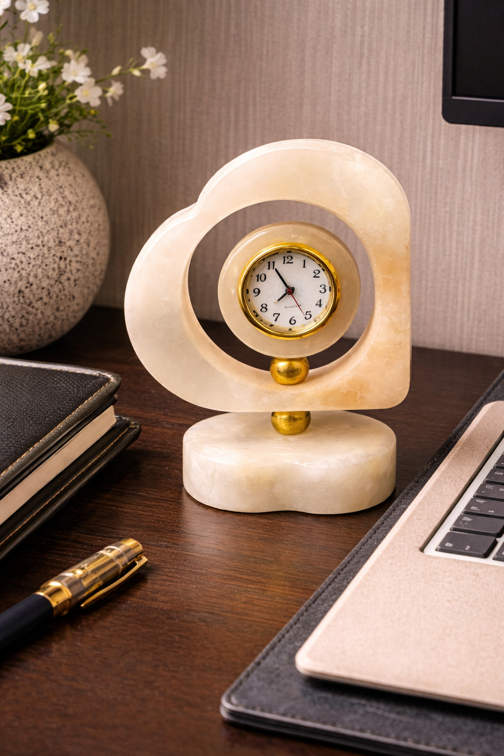 Handcrafted heart-shaped onyx marble desk clock on office desk beside laptop and notebook – elegant luxury stone décor for modern workspace styling.