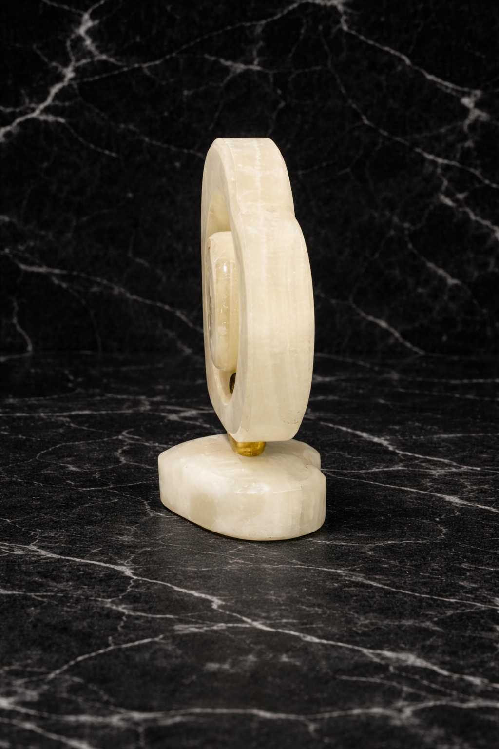 side view of Luxury heart-shaped onyx desk clock on black marble surface