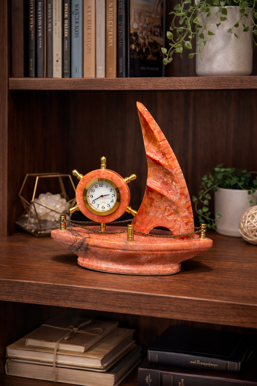 Red onyx sailboat marble clock on study desk with books – unique nautical desk décor.