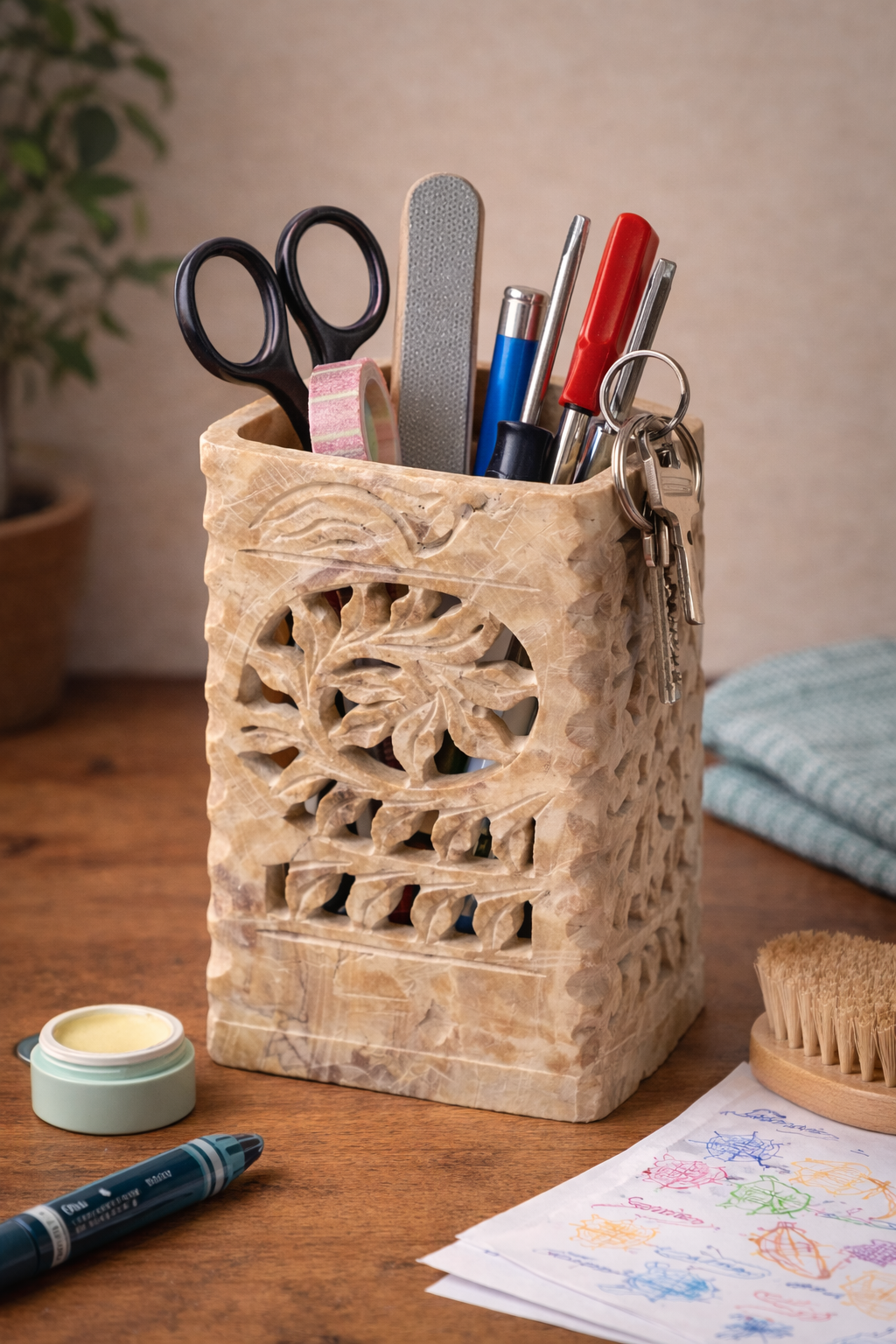 Floral carved soapstone stand used to store everyday household items on a wooden table.